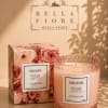 Pink rose-scented candle in a textured glass jar with matching box