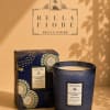 Blue patterned candle in a box beside a matching candle jar