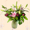 Pink lilies and dark pink tulips in a textured glass vase