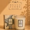Glass candle in a patterned box beside a matching candle jar
