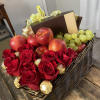 Basket of red roses, apples, grapes, and chocolates with a gift box