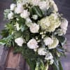 Large white floral arrangement with roses and hydrangeas