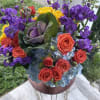 Colorful bouquet of roses, purple stock, and blue hydrangeas in a vase