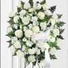 White rose and carnation standing spray with a white ribbon