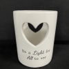 White ceramic candle holder with a heart cutout and printed text