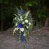 Tall standing floral spray with white and blue flowers on an easel