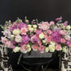 Lush pink peonies and soft ranunculus create a romantic, garden-fresh centerpiece perfect