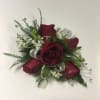 Red rose corsage with white filler and silver ribbon