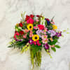 Mixed bouquet of roses, sunflowers, and orchids in a glass vase
