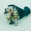 White orchid corsage with purple accents on a dark wristlet