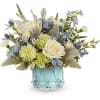 Blue and white floral arrangement in a light blue glass vase