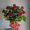 Classic one dozen red roses in a vase with filler and green.