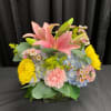Pink lilies and mixed blooms in a glass vase