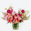 Pink and coral mixed bouquet in a clear glass vase