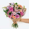 Hand-tied bouquet of pink and peach roses with mixed pastel flowers