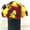 Bouquet of red and yellow roses with green button mums in a black box