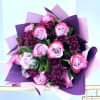 Bouquet of pink roses and dark purple chrysanthemums wrapped in purple paper