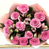 Bouquet of pink roses and light pink alstroemeria wrapped in soft pink paper