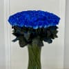 Large bouquet of vivid blue roses in a clear glass vase