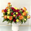 Bouquet of red, yellow, and orange roses in a white vase