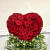 Heart-shaped arrangement of red roses with white filler flowers