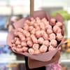 Large bouquet of pale pink roses wrapped in pink paper