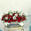 Red roses and white anemones in a low gray bowl