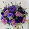 A luxurious arrangement featuring rich purple lisianthus, deep violet blooms, and soft