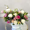 A graceful arrangement featuring soft blush roses, pure white blooms, and delicate