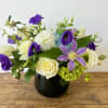 Purple and white mixed bouquet in a dark vase