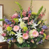 Large mixed floral arrangement with pink, white, purple, and green blooms