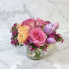 Pink and peach flowers arranged in a clear glass vase