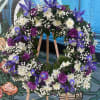 Purple and white floral wreath on a wooden easel