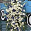 Tall white and blue floral standing spray on an easel
