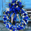 Blue and white floral wreath on a wooden easel with a ribbon bow