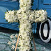 Seasonal white flowers arranged into a cross spray. 