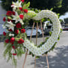 Seasonal red and white flowers arranged into a heart easel.