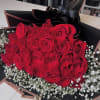 A timeless flat bouquet featuring 24 premium roses paired with delicate baby&rsquo;s