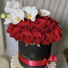 Red roses in a black round box with white orchids on top