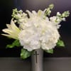 White hydrangea and lilies arranged in a silver vase with a cross cutout