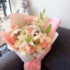 Pink and white bouquet with roses and lilies wrapped in pastel paper