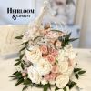 Pink and white roses arranged in a white birdcage