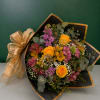 Bouquet of yellow roses and pink-purple mixed flowers wrapped in black paper with gold trim