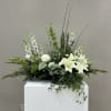 This funeral piece includes at least two houseplants for use as keepsakes