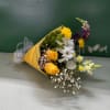 Bouquet of yellow, white, and purple flowers wrapped in yellow paper