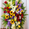 A dramatic upright standing spray that reads like a celebratory farewell -