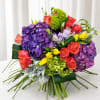 A dramatic cluster of large purple hydrangea heads anchors this wedding bouquet