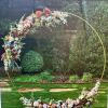 Floral arch arrangement on a gold metal hoop with pastel flowers