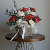 A cheerful cluster of red and white carnations in a low woven