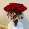 Bouquet of red roses with pink filler flowers in a glass vase